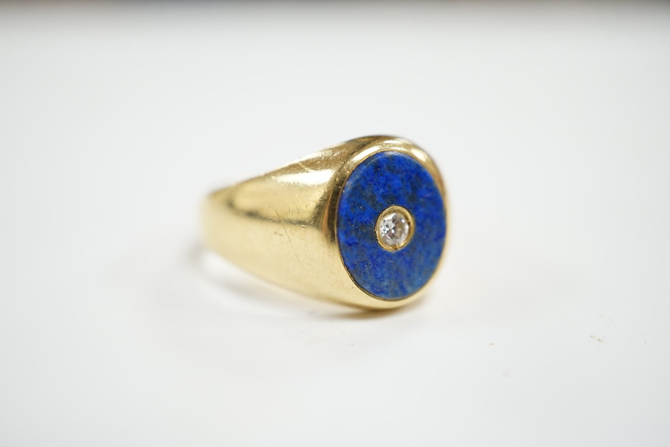 A mid to late 20th century Italian 750 yellow metal and oval lapis lazuli set signet ring, with inset diamond, size U, gross weight 12 grams.